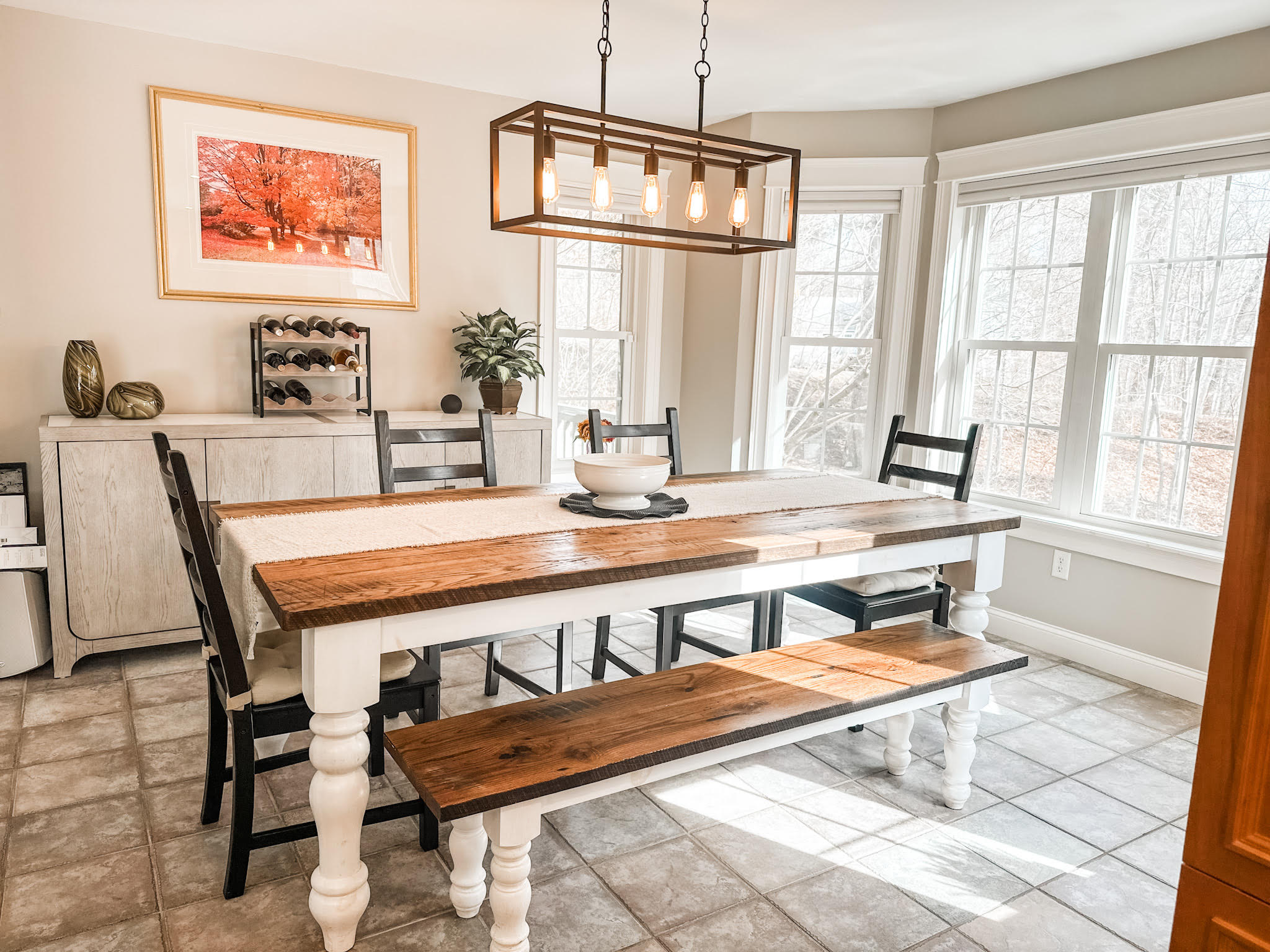 A reclaimed oak farmhouse dining table with a matching bench in a bright room